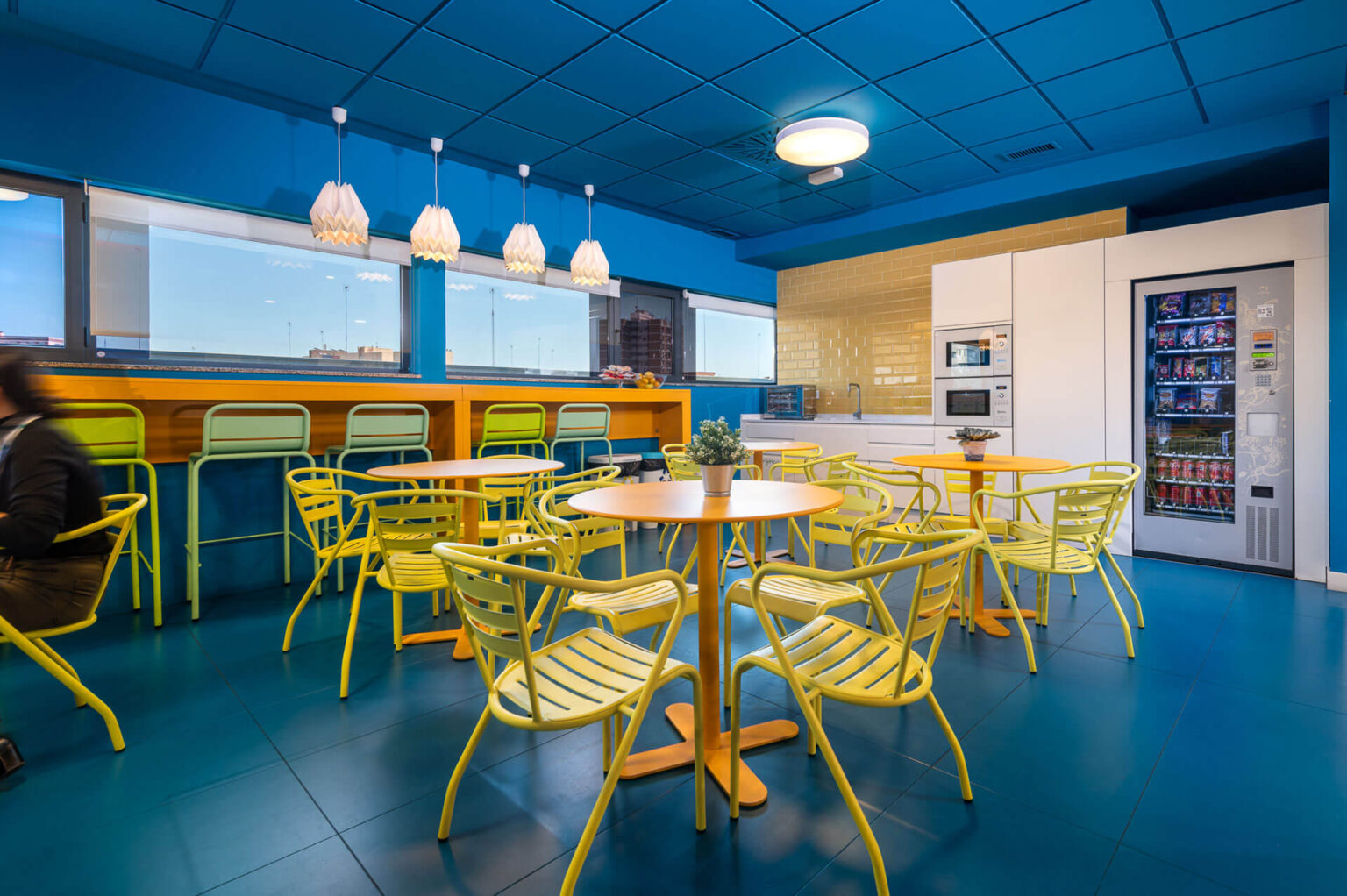 espacio-comun-con-mesas-y-sillas-para-comer-maquinas-de-vending-isspaces-insur