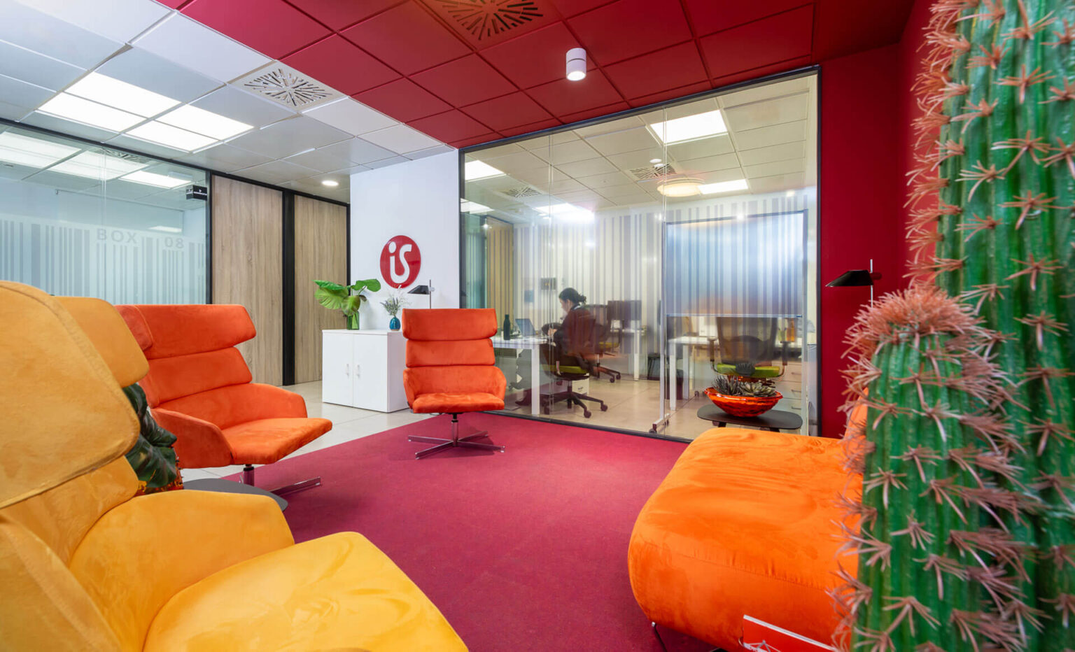 sala-de-desacanso-con-paredes-rojas-y-sofas-naranjas-y-amarillos-isspaces-insur